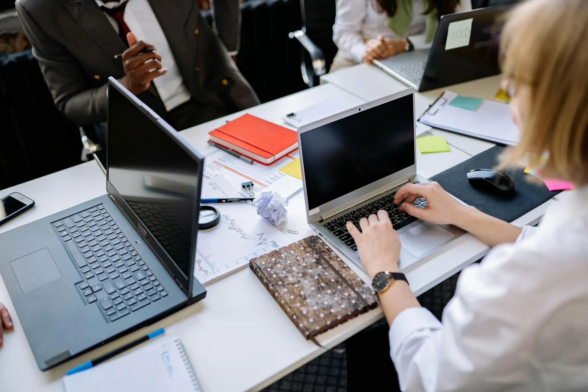 A business professional typing on a laptop in an office
